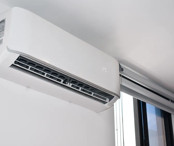 A wall-mounted ductless mini-split air handler in a bright room