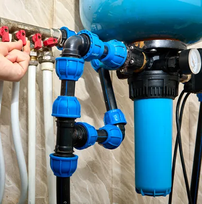 A commercial water treatment manifold with blue filtration housings