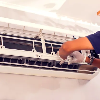 A technician servicing the filter of a wall-mounted ductless mini-split